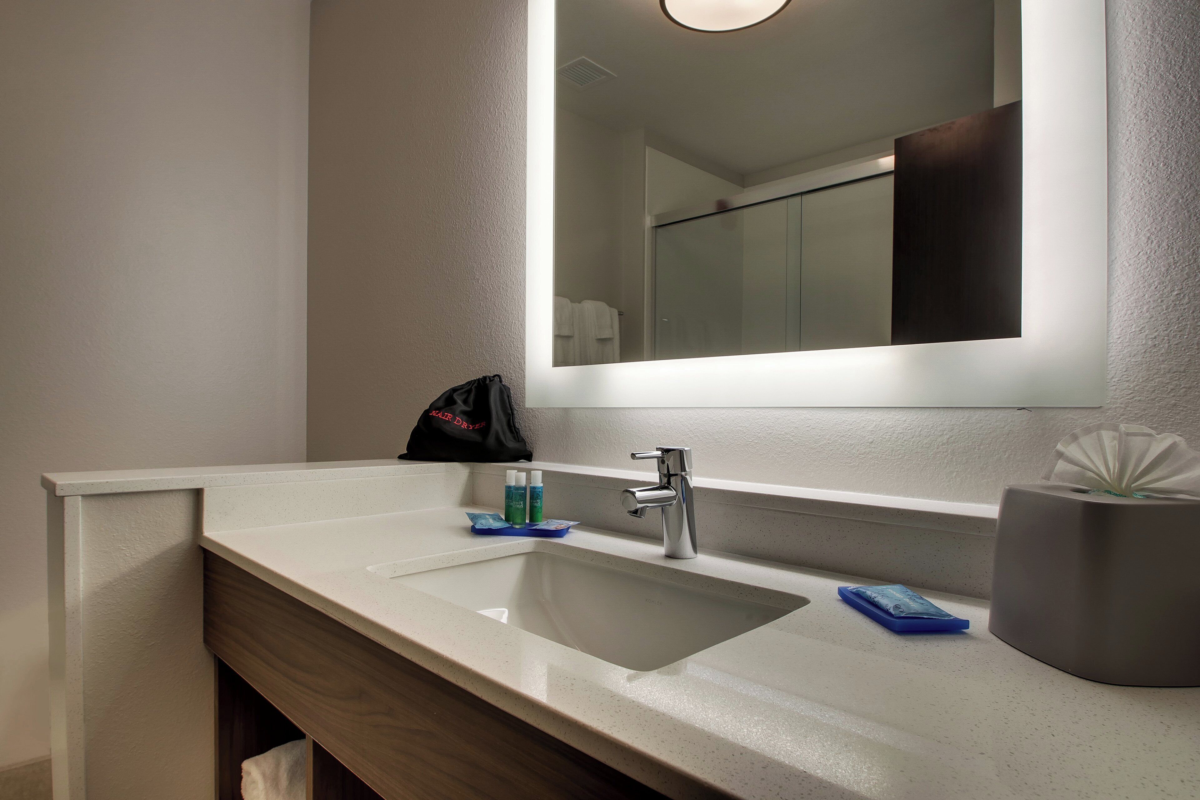 Une salle de bain avec un lavabo blanc, un miroir et un porte-serviettes.