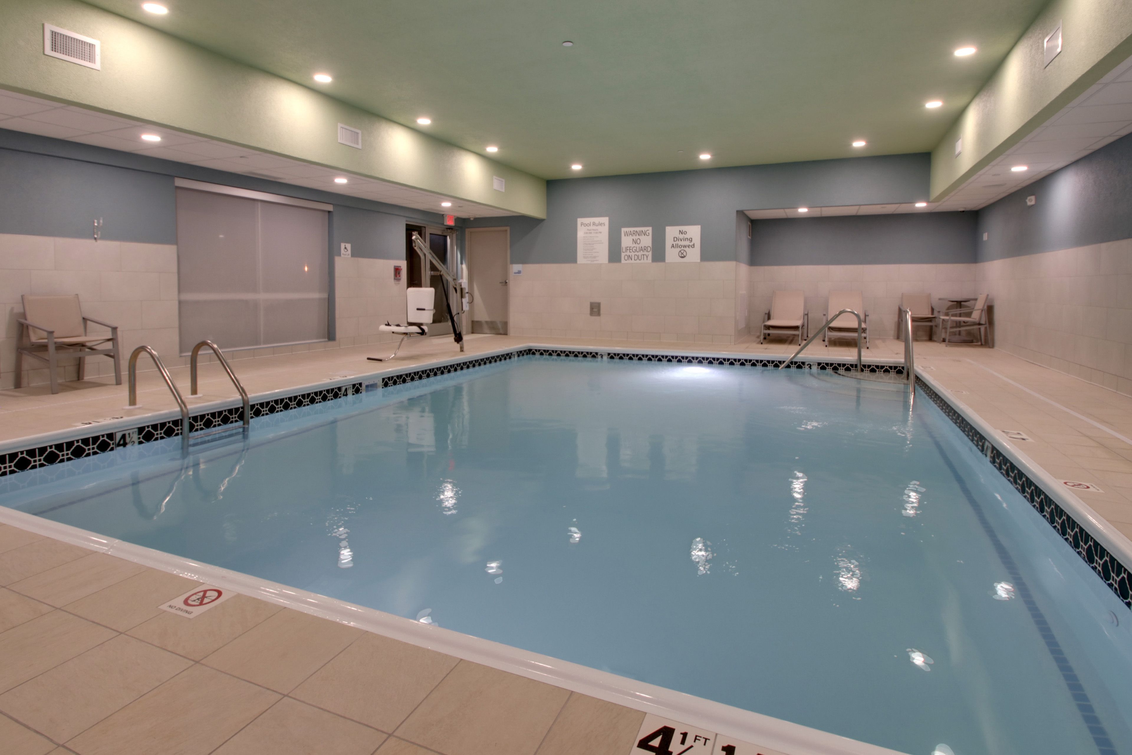 Una piscina techada, sillones reclinables de piscina