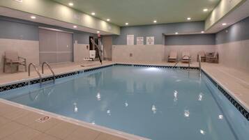 Una piscina techada, sillones reclinables de piscina