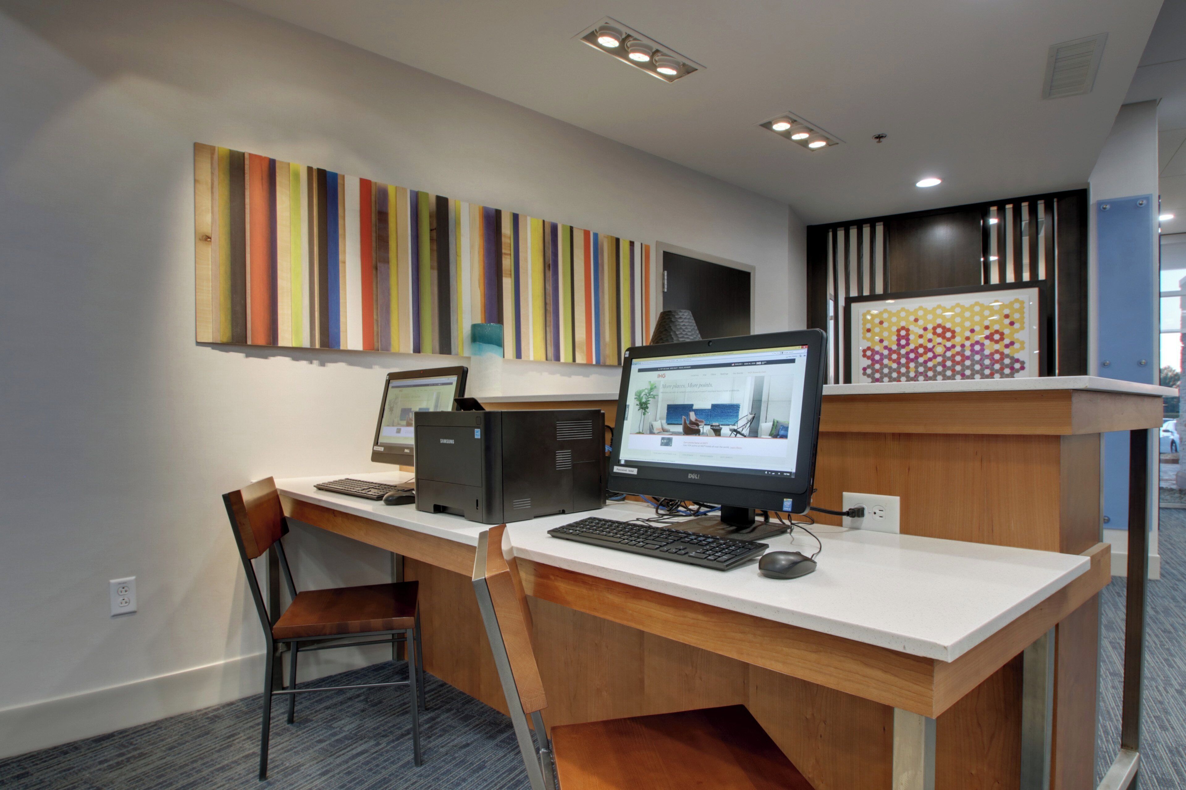 A workspace with two desktop computers, a chair, and a desk.