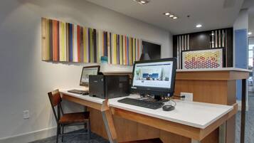A workspace with two desktop computers, a chair, and a desk.