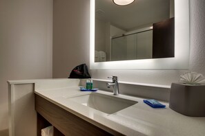 Une salle de bain avec un lavabo blanc, un miroir et une serviette accrochée au mur.
