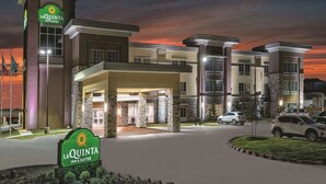 A La Quinta Inn & Suites building with a modern architectural design, featuring a prominent entrance and a landscaped driveway. - La Quinta by Wyndham San Antonio by Frost Bank Center (San Antonio)