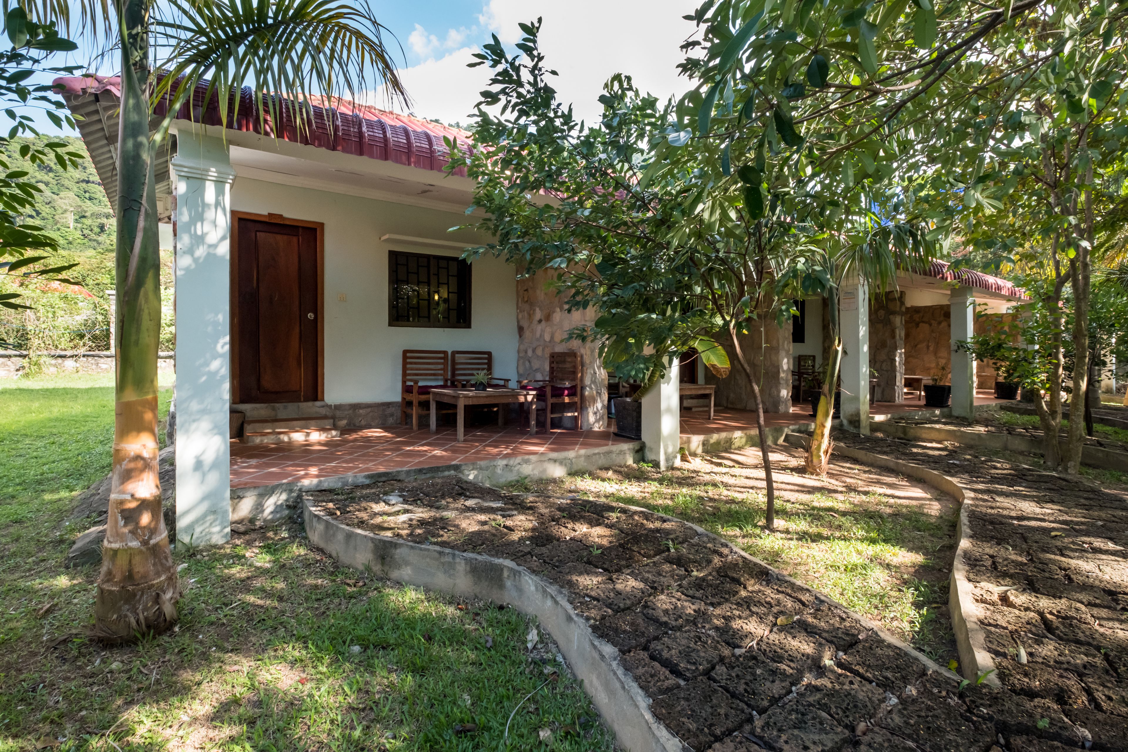 A house with a patio, a garden, and a small outdoor seating area.