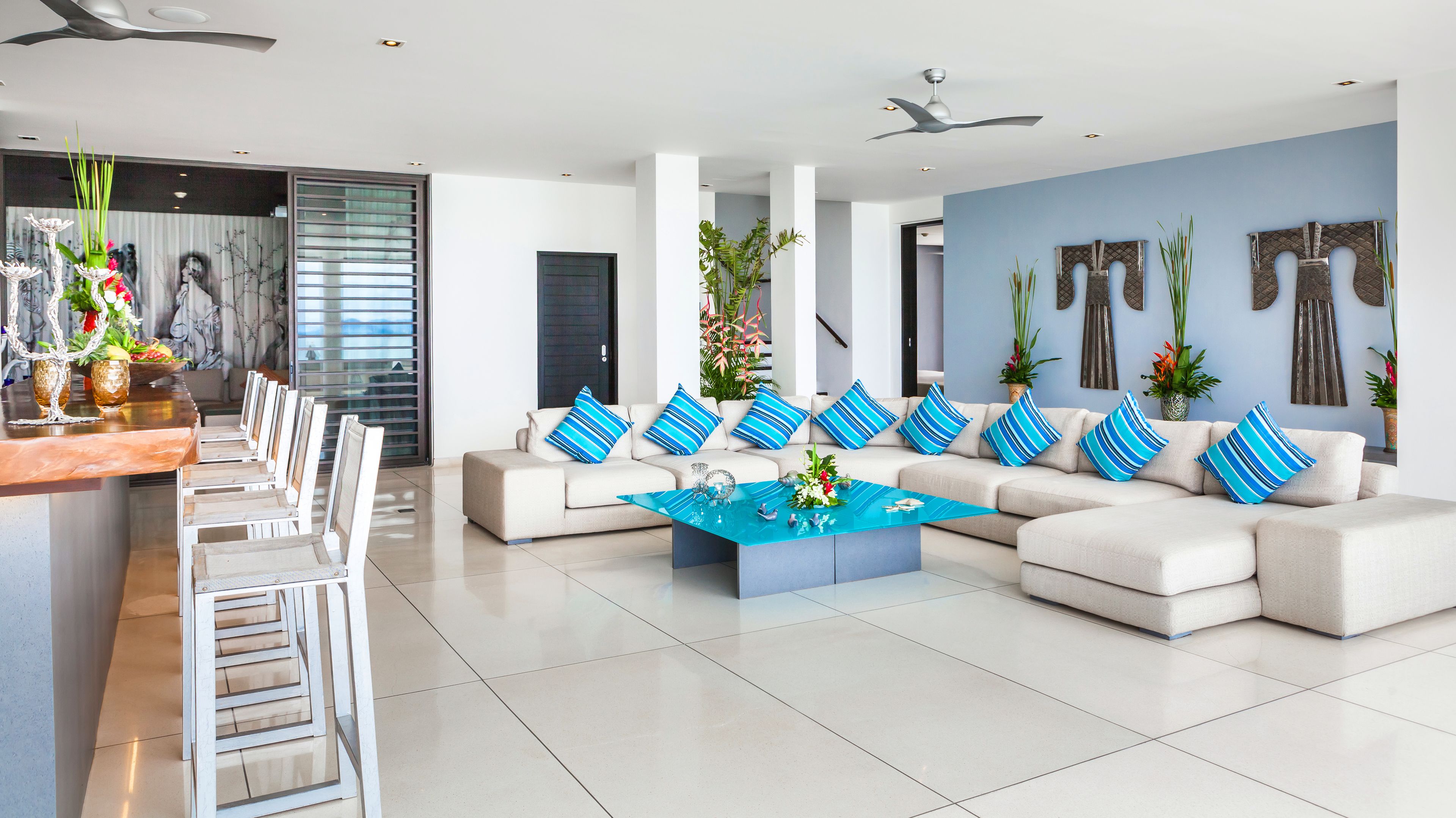 A modern living room with a sofa set, a coffee table, and a dining area with chairs.