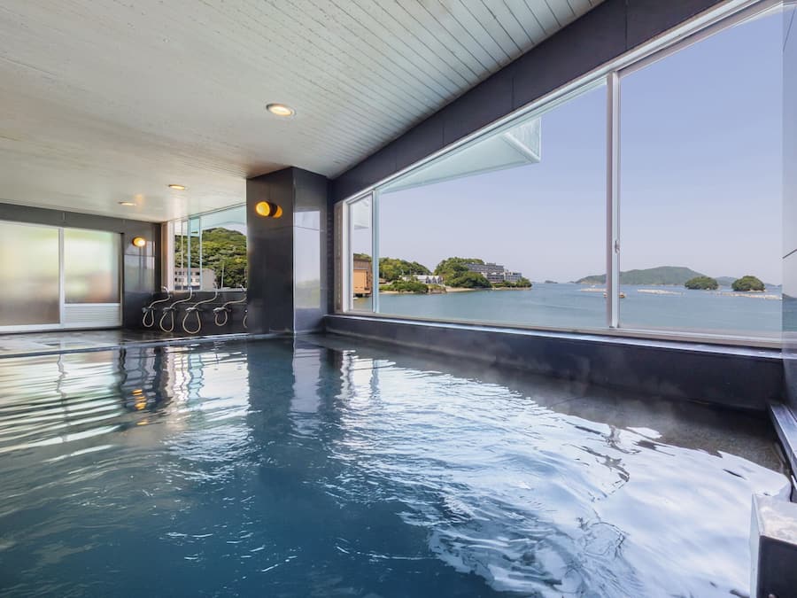 Ein Hallenbad mit freiem Blick auf das Meer und entfernte Inseln.