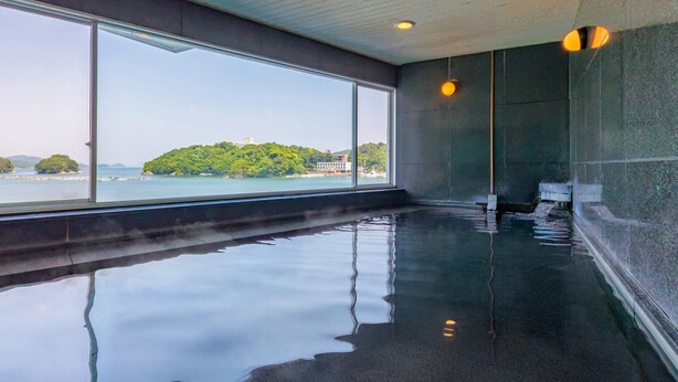 A large indoor swimming pool with a view of a forested island across the water. - Wan Wan Paradise Toba (Toba)