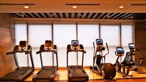Une salle de remise en forme équipée de cinq tapis de course et d’un appareil elliptique.