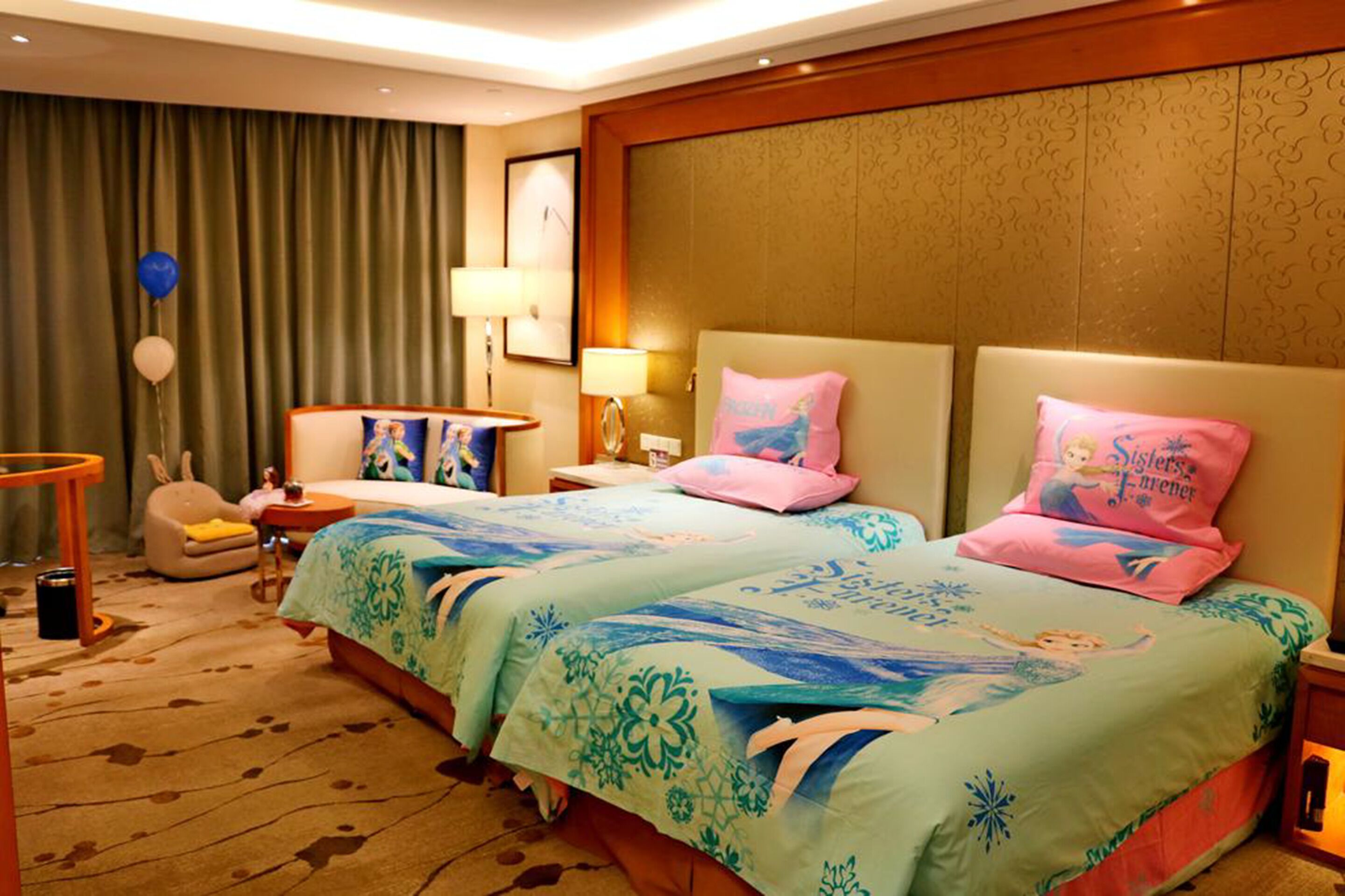 A hotel room with a large bed, two bedside tables, a chair, a desk, and a lamp.