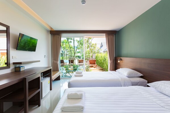 A hotel room with a desk, two beds, a TV, and a view of the outdoors. - Parida Resort (Choeng Thale)