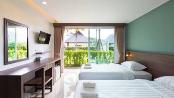 A hotel room with a bed, a desk, a TV, and a view of the outdoors.
