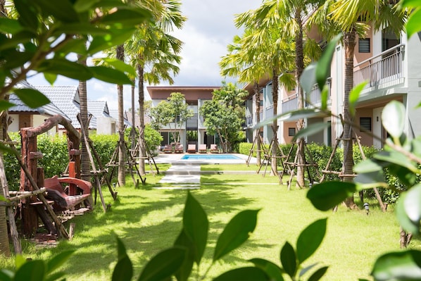 Un resort con piscina, palmeras y cielo despejado.