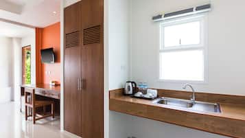 A modern kitchen with a wooden countertop, a built-in sink, and a window above the sink.