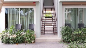 A modern building with a staircase leading to a balcony, surrounded by potted plants. - Parida Resort (Choeng Thale)