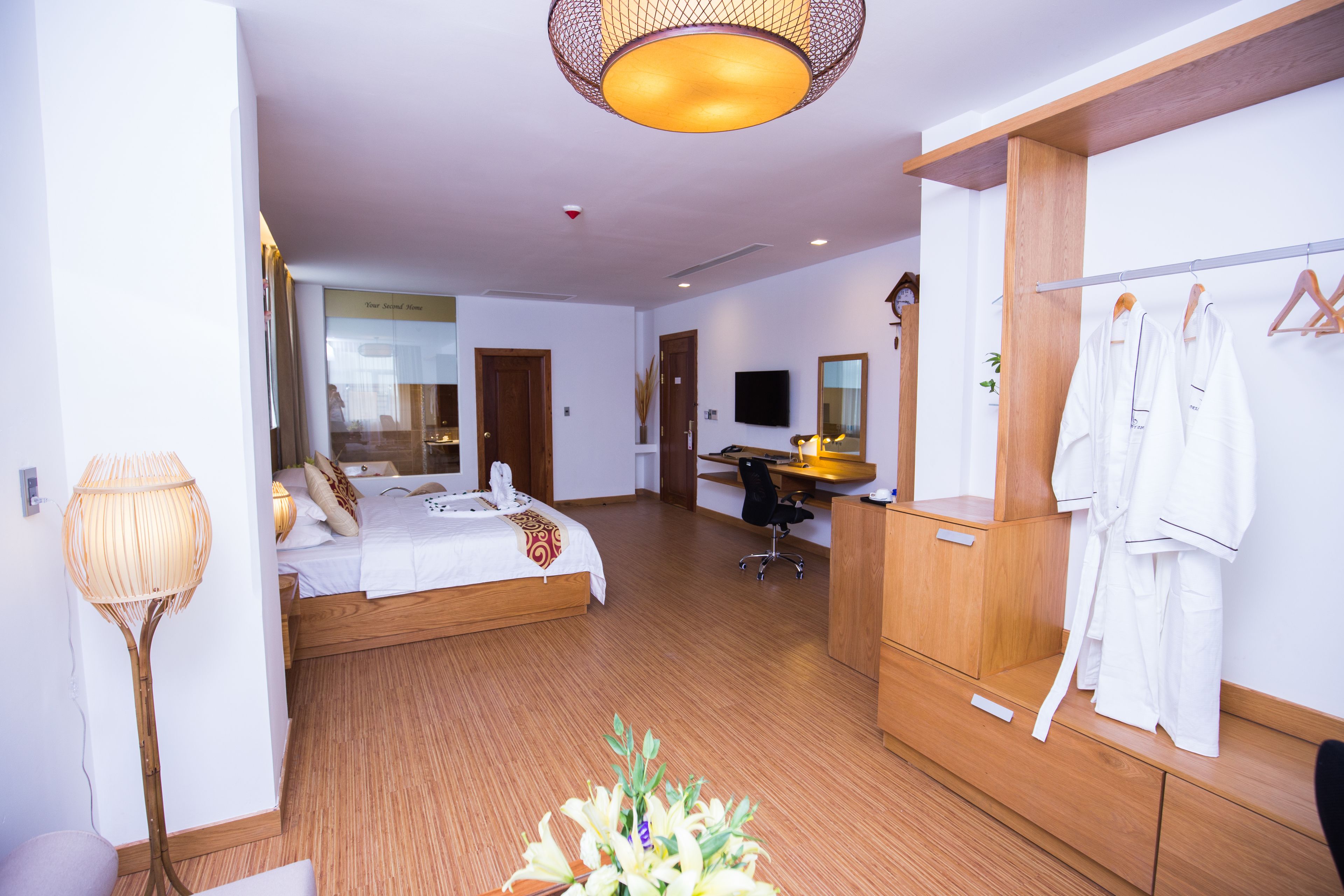 A hotel room with a bed, desk, and wardrobe.