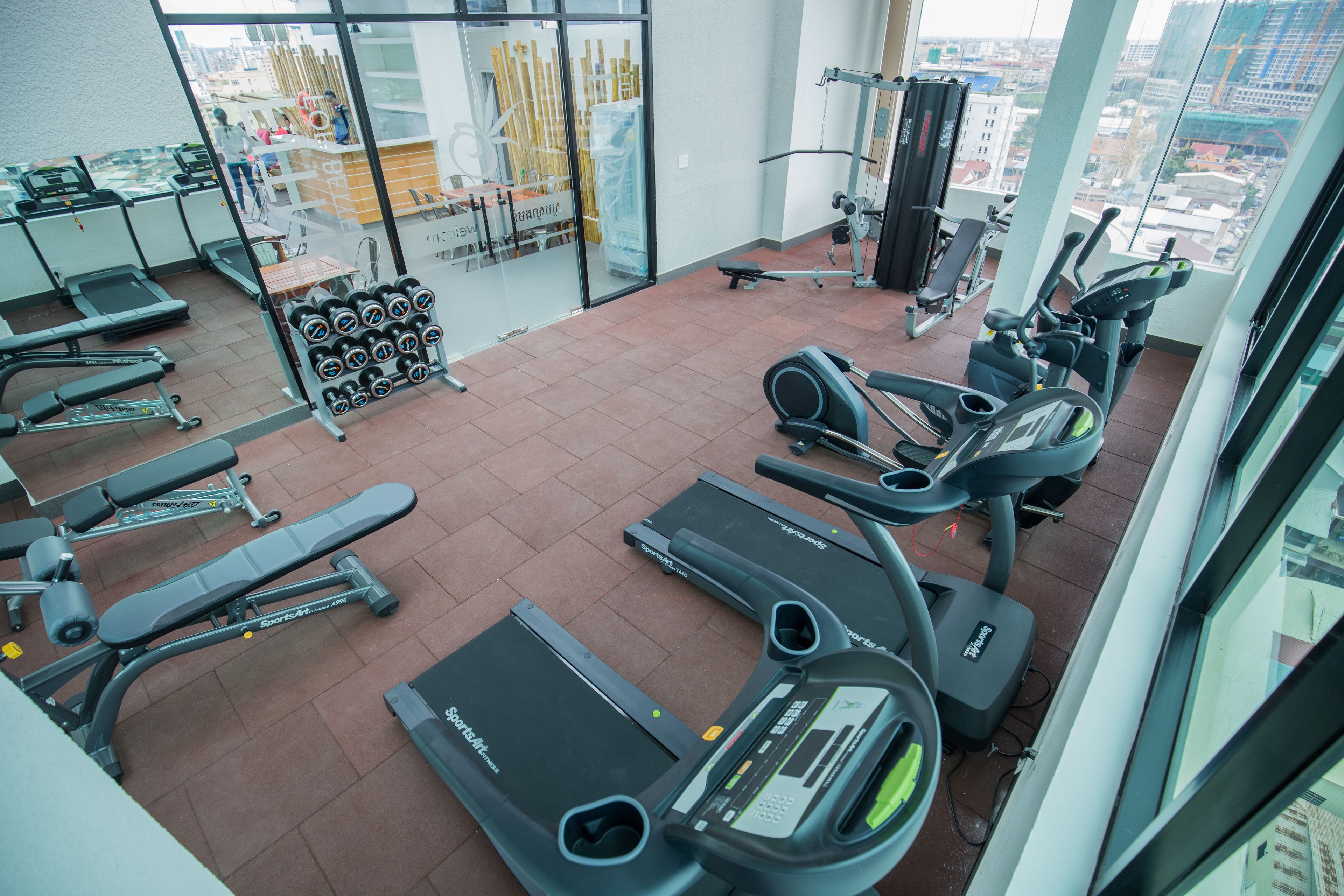 Et fitnesscenter med løbebånd, crosstrainere og styrkemaskiner.