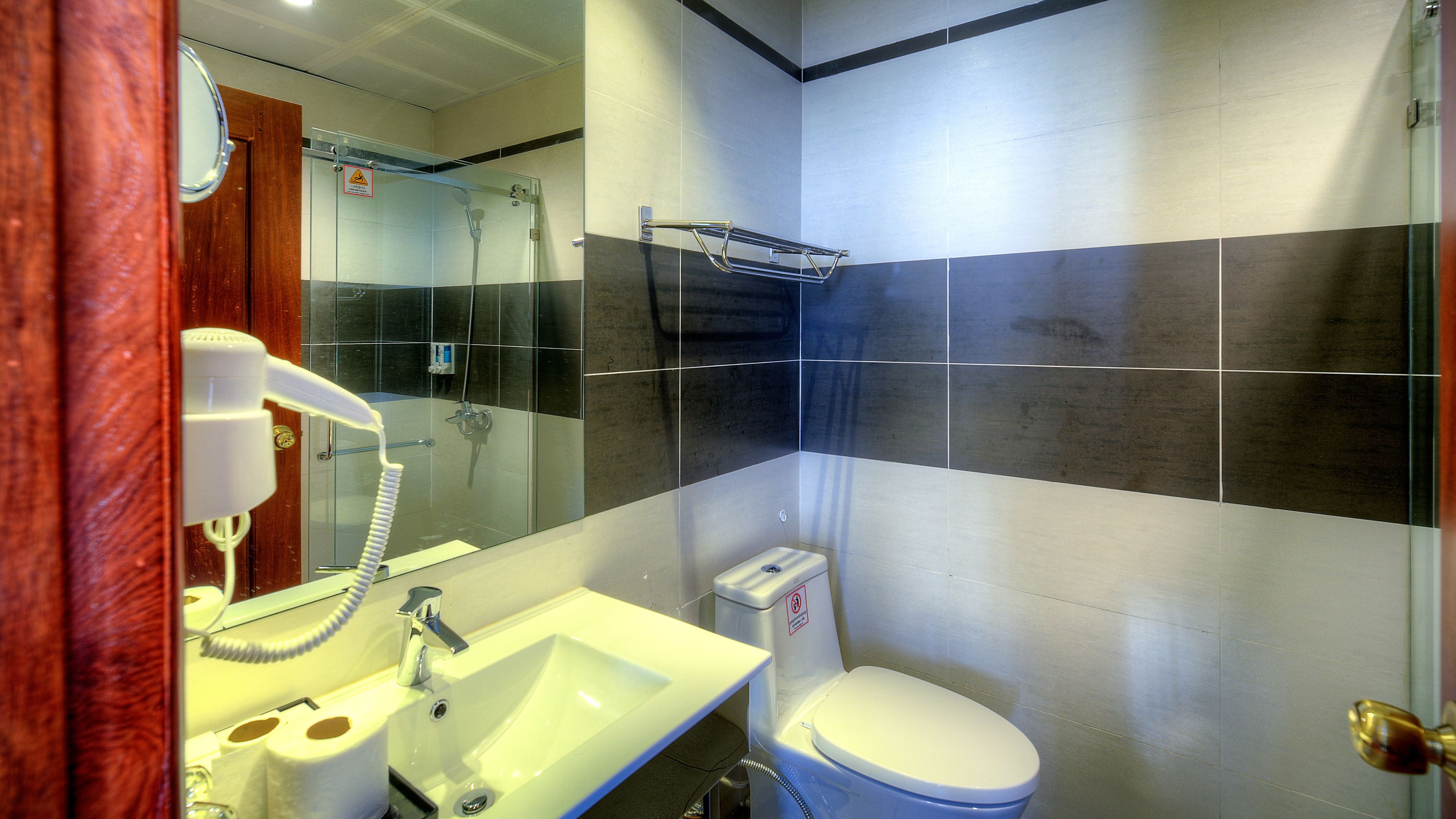 Un baño moderno con cabina de ducha de vidrio, un lavamanos blanco y un inodoro.