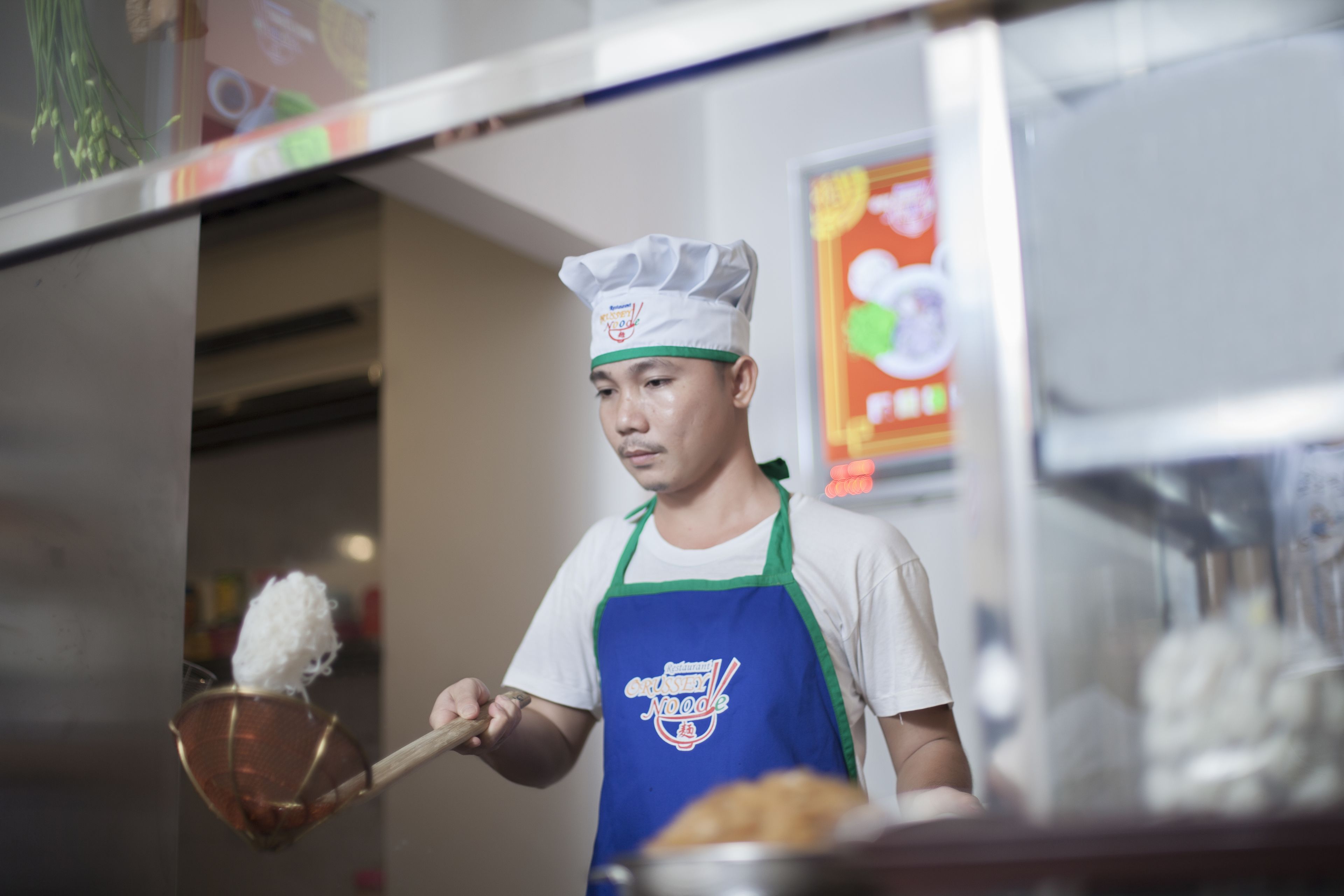 Una persona con cappello da chef e grembiule che prepara del cibo.