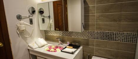 A modern bathroom with a vanity, mirror, and toilet.
