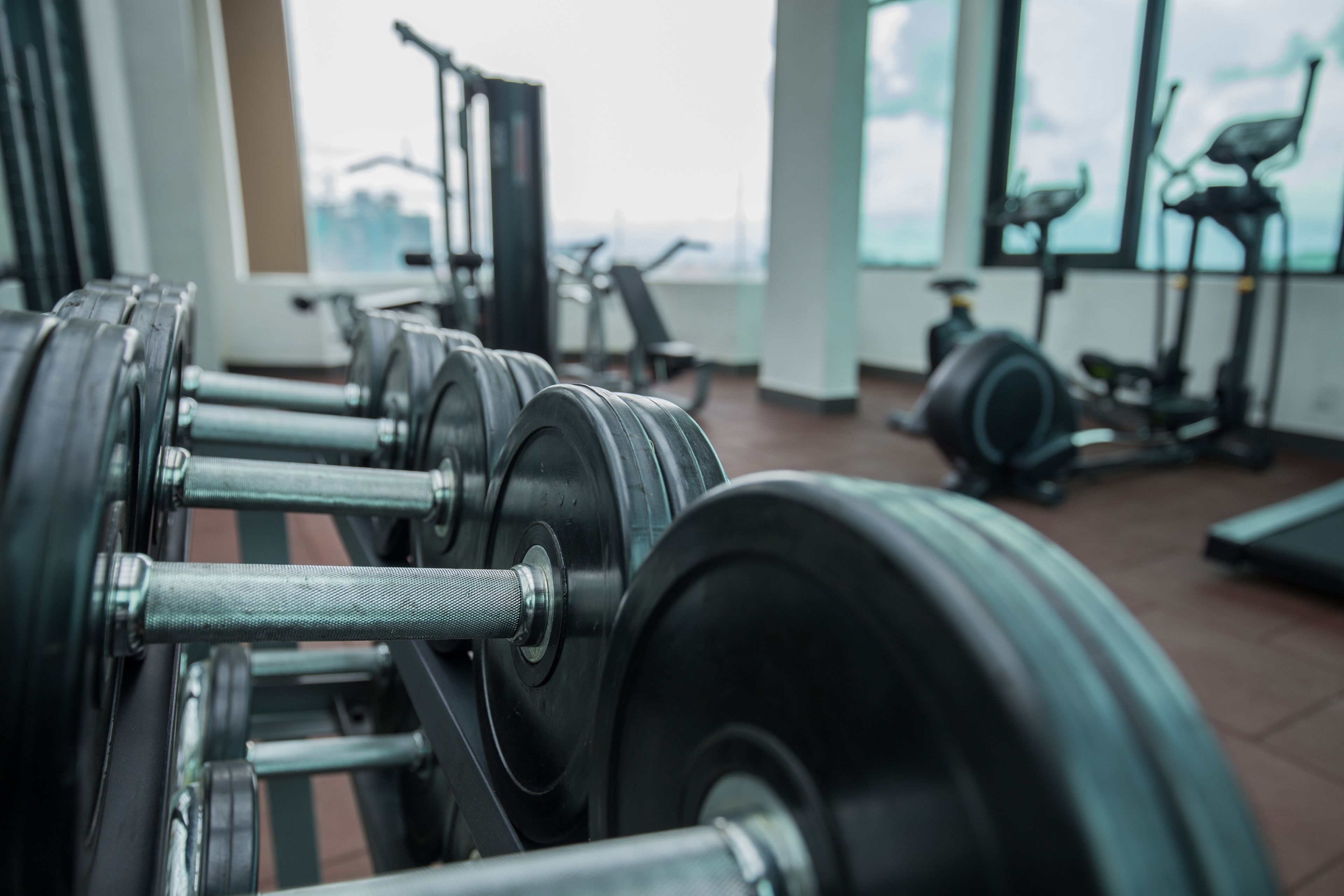 Een fitnessruimte met trainingsapparatuur, waaronder gewichten en loopbanden.