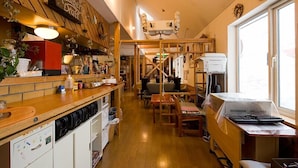 Una cocina con armarios de madera, una encimera y un comedor con mesa y sillas.