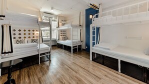 Una habitación con literas, un sofá y una pequeña mesa.