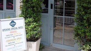 Un edificio con un letrero que dice "THE QUARTER" y un cartel anunciando tarifas y servicios especiales.