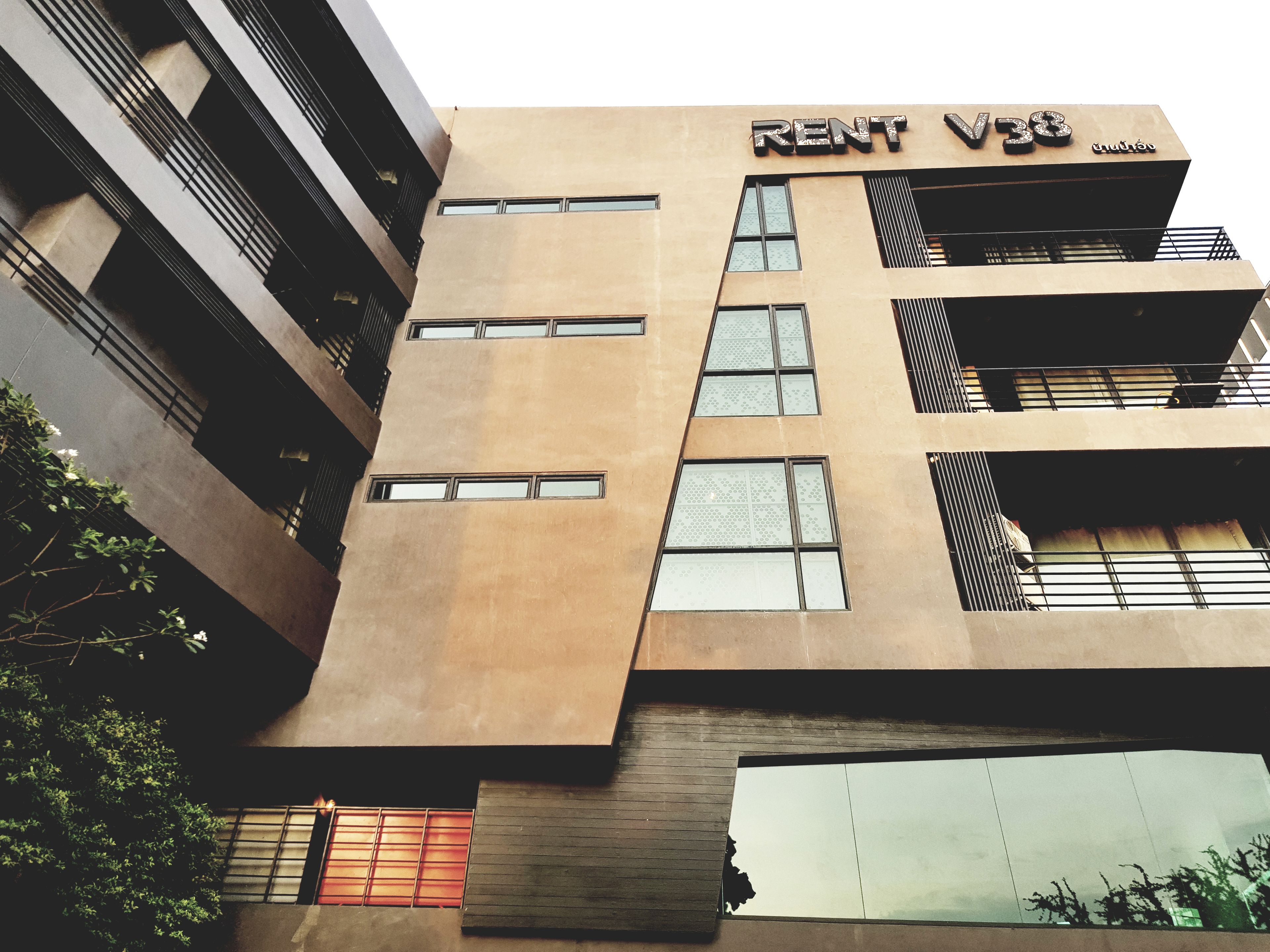 Un edificio de varios pisos con un letrero que dice 'RENT V38'.