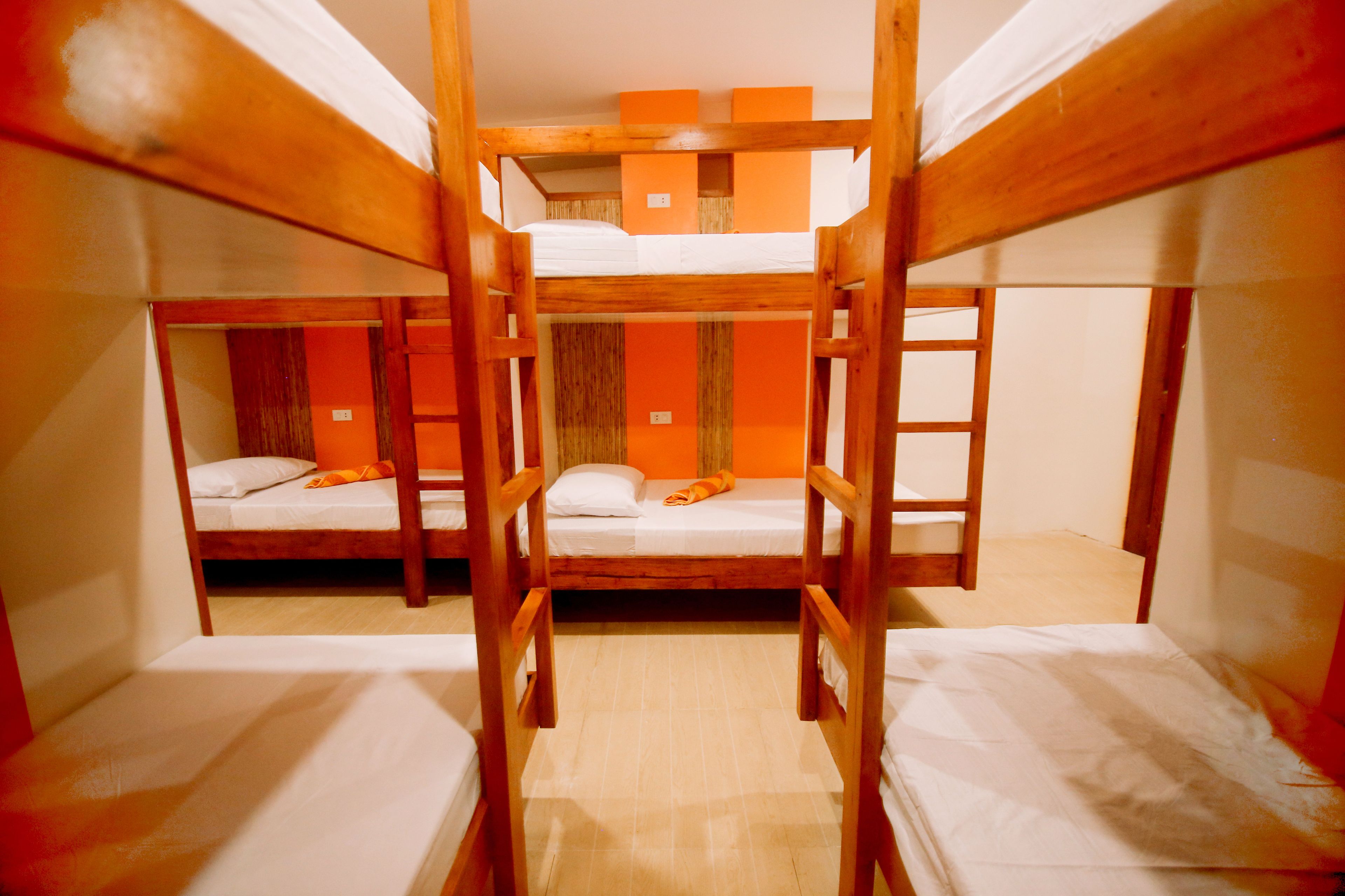 A bunk bed room with wooden frames and orange accents.