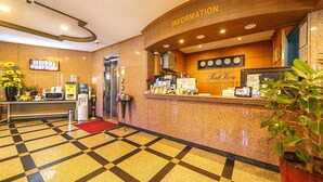 A hotel reception area with a check-in counter, information desk, and a clock. - Port View (Yangyang)