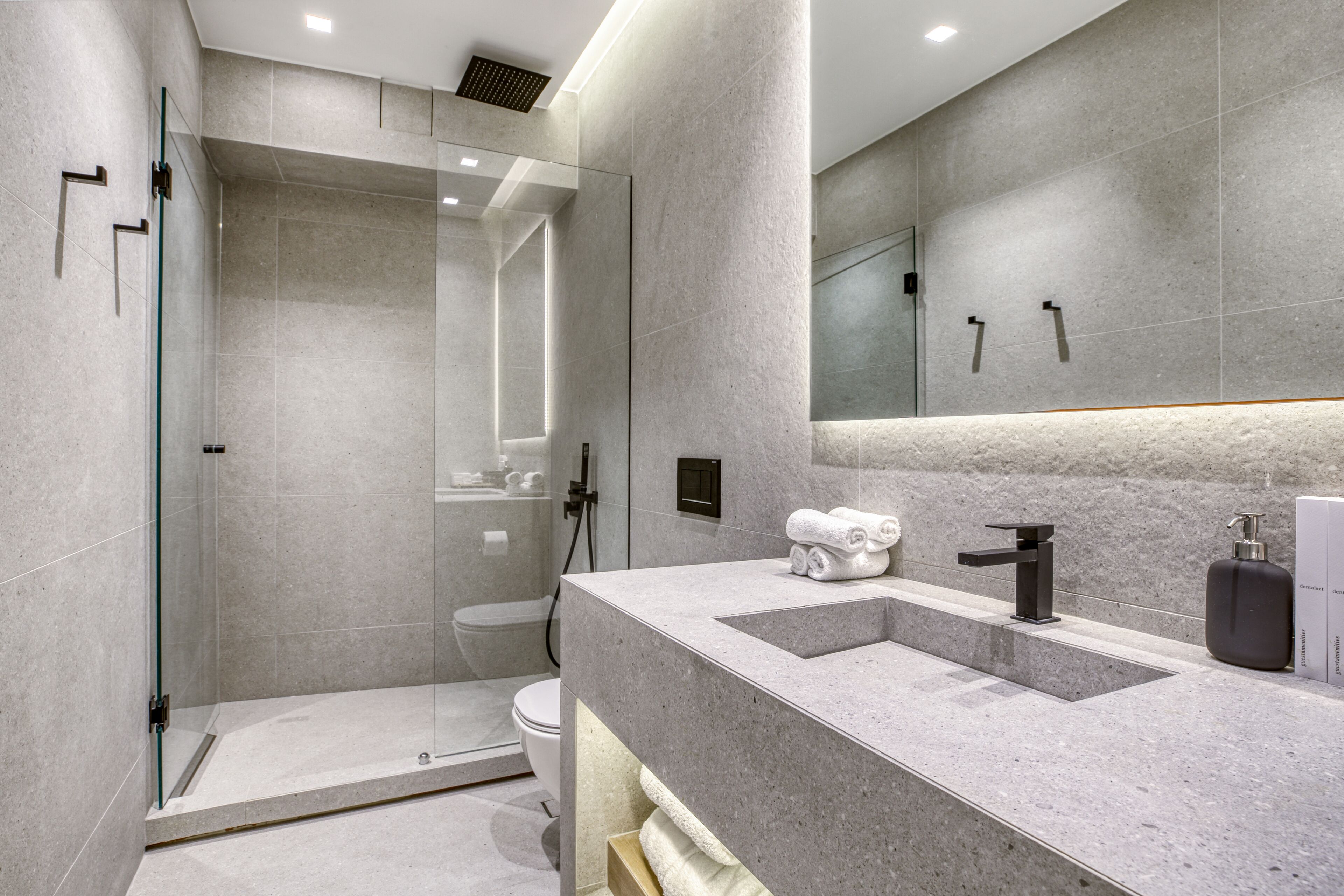 Une salle de bain moderne dotée d’une douche à parois de verre, d’un meuble-lavabo à deux vasques et d’un grand miroir.