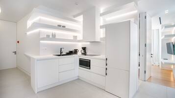 Departamento Deluxe, balcón | Cocina privada | Refrigerador, microondas, horno y parrilla de estufa