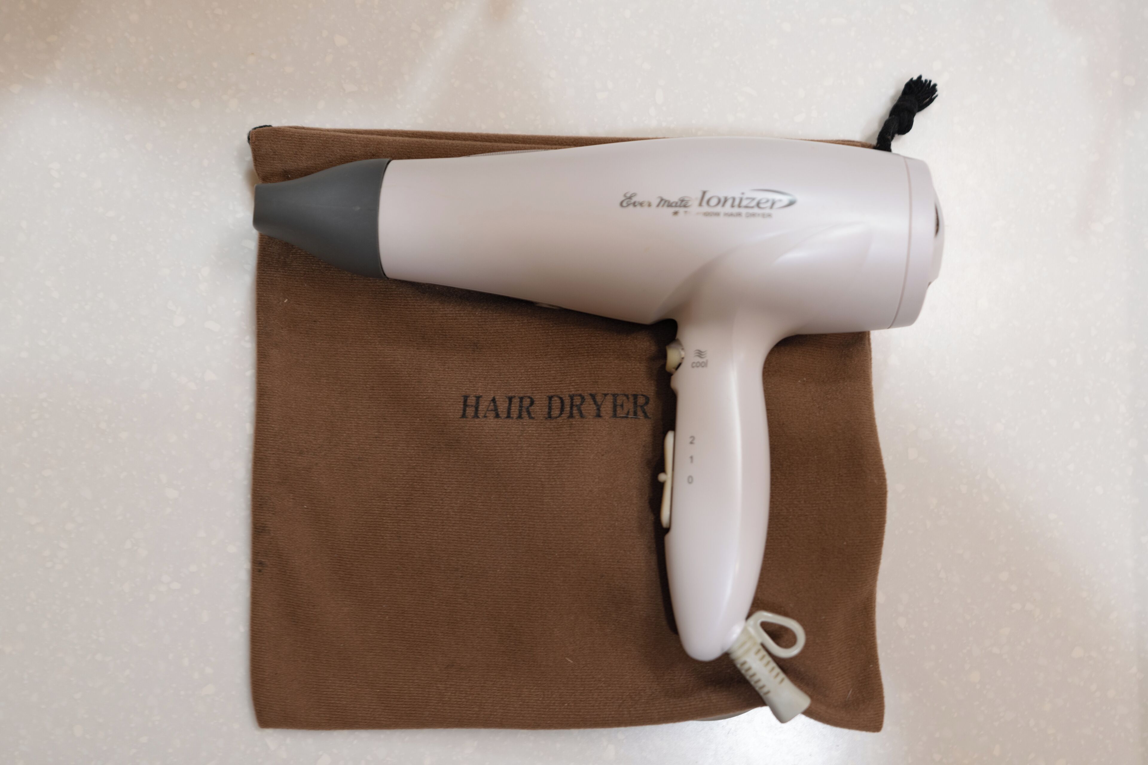 Un secador de pelo sobre un paño marrón con el texto "HAIR DRYER".