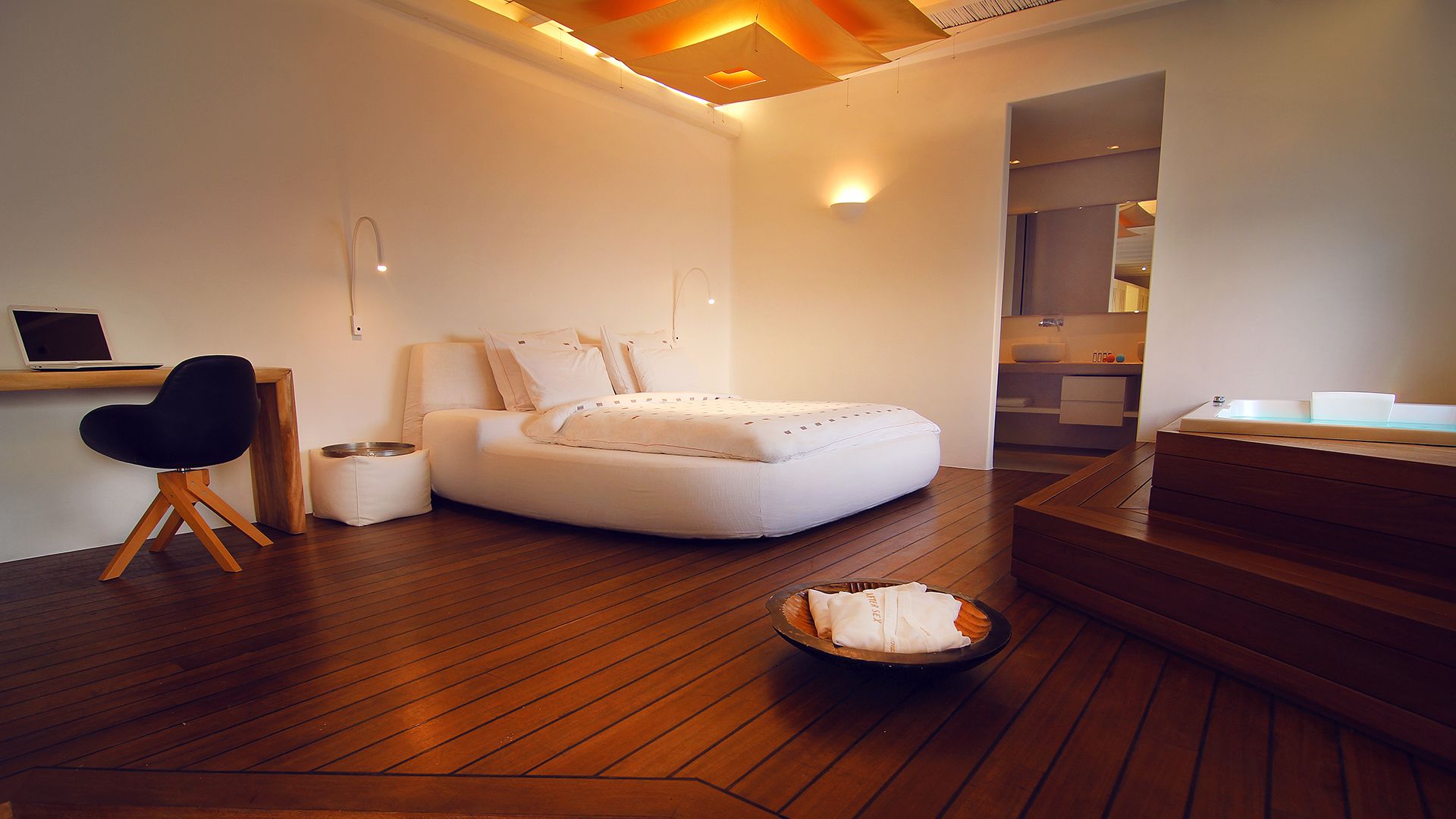 Un dormitorio moderno con cama, escritorio y silla.