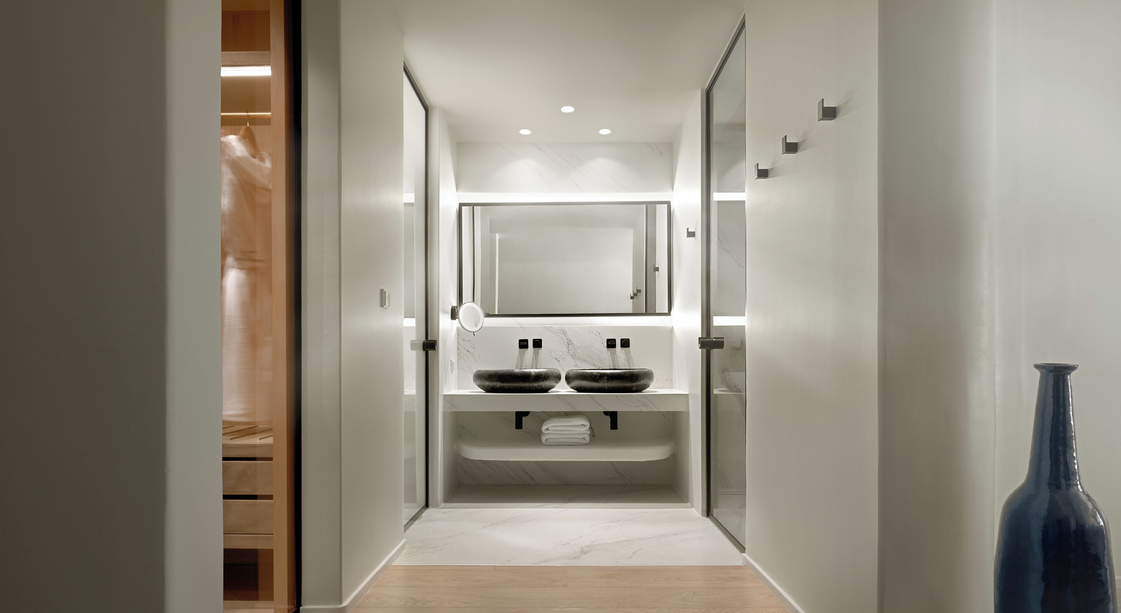 Une salle de bain moderne avec un double vasque, un miroir et un meuble-lavabo en bois.