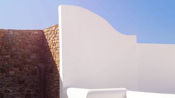 A stone wall adjacent to a white, curved structure.