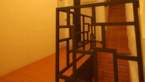 A staircase with a wooden handrail and a black metal guardrail. - Hananoi Bed and Breakfast (Hengchun)