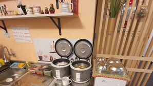 A compact kitchen with a sink, two electric kettles, a small refrigerator, and a microwave. - 24 Guesthouse Seomyun (Busan)