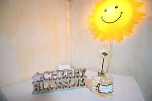A table with a wooden sign reading "CHEERY BLOSSOM" and a bottle of perfume. - 24 Guesthouse Seomyun (Busan)