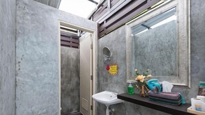 A bathroom with a sink, mirror, and toiletries on the counter.