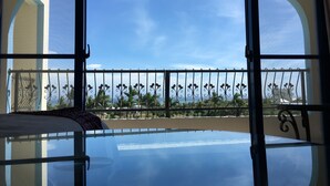 A room with a large glass window and a balcony with a metal railing. - Happiness House (Chenggong)