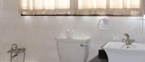 A bathroom with a toilet, sink, and bathtub.