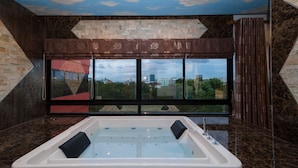 A modern bathroom with a large bathtub, a city view through a large window, and a ceiling with a cloud mural. - Thongtara House Boutique Residence (Samut Prakan)