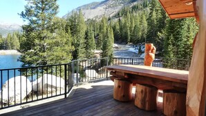 A wooden deck with a bench overlooking a river and forested mountains. - Elk Creek Lodge 3 Bedroom Holiday Home By Pinon Vacation Rentals (Salida)