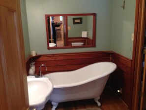 A bathroom with a freestanding bathtub, a sink, and a mirror above the sink. - Forest Creek Cabin 3 Bedroom Holiday Home By Pinon Vacation Rentals (Monarch)