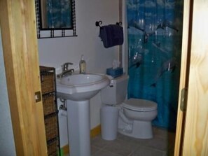 A bathroom with a sink, toilet, and a shower curtain with a blue pattern.