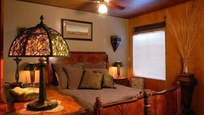 A cozy bedroom with a wooden bed, a decorative lamp, and a ceiling fan. - Heister House 3 Bedroom Holiday Home By Pinon Vacation Rentals (Salida)