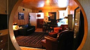 A circular room with a wooden ceiling, a sofa, a coffee table, a TV, and a dining area. - Heister House 3 Bedroom Holiday Home By Pinon Vacation Rentals (Salida)