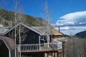 A wooden cabin with a balcony, surrounded by trees and mountains. - Mountain High 2 Bedroom Holiday Home By Pinon Vacation Rentals (Monarch)