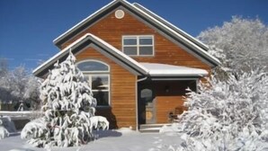 Une maison en bois avec un toit à pignon et une porte d’entrée.